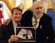 Carl Walker shows Vangelis a photograph of his badge, floating inside the International Space ...jpg